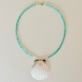 Necklace with turquoise beads and a shell pendant on a light background