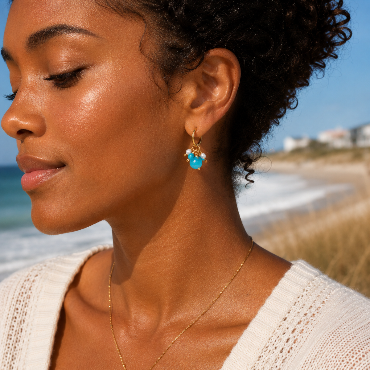 Woman wearing turquoise earrings on a beach