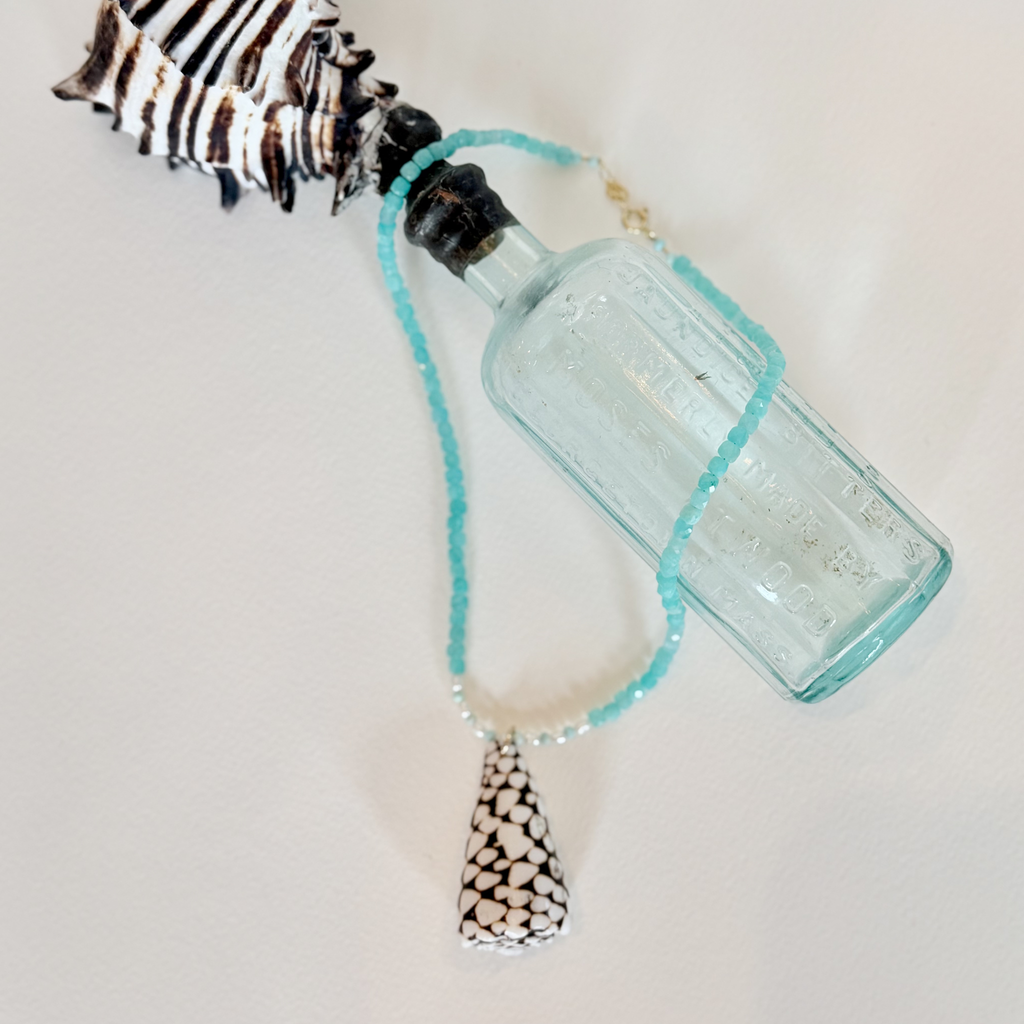 Vintage-style blue glass bottle with decorative elements on a light background