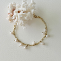 Gold bracelet with pearls on a white background