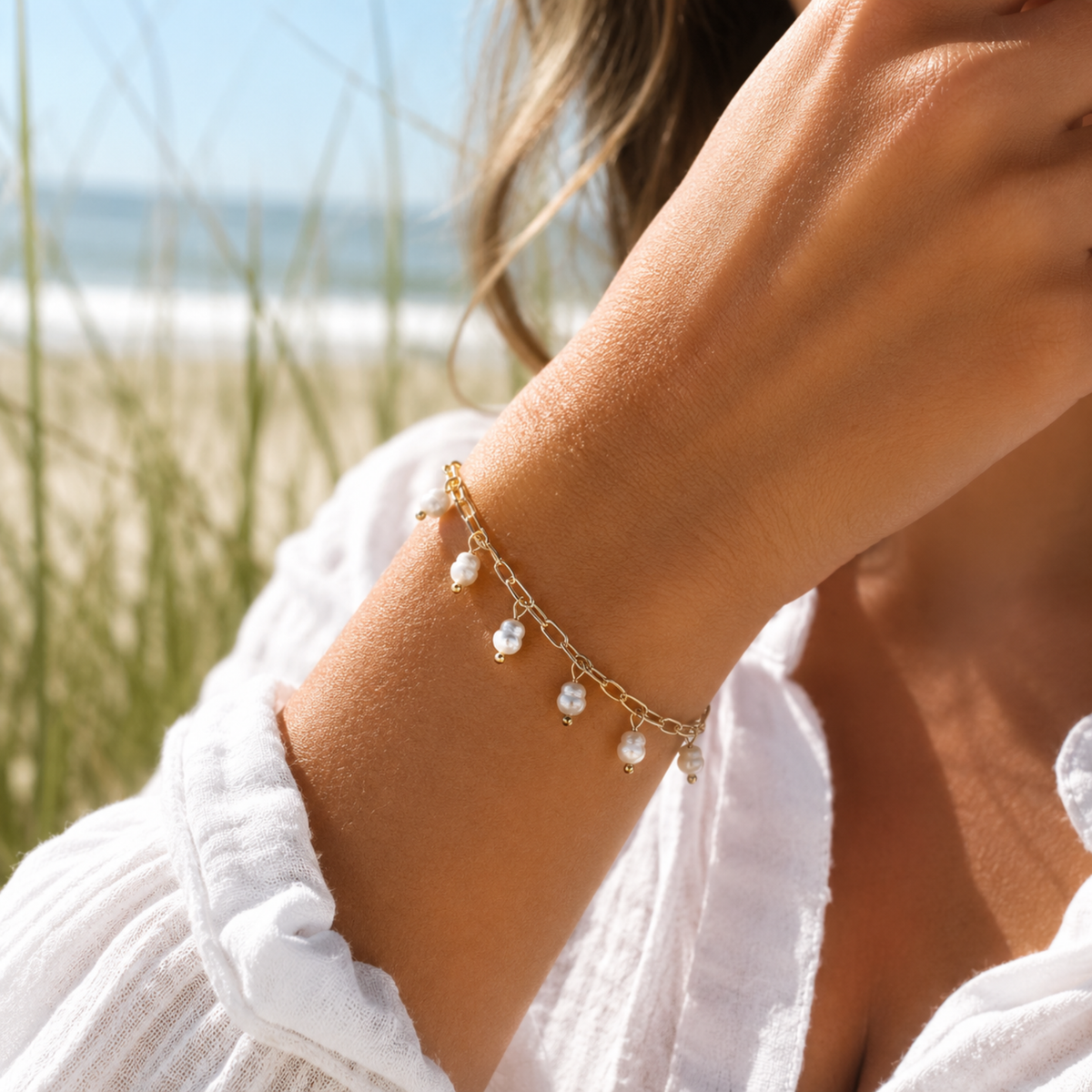 Pearl bracelet on a wrist with a beach background