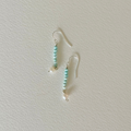 Pair of turquoise beaded earrings on a light gray background