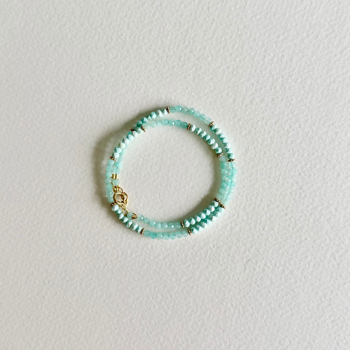 Turquoise beaded bracelet on a light gray background