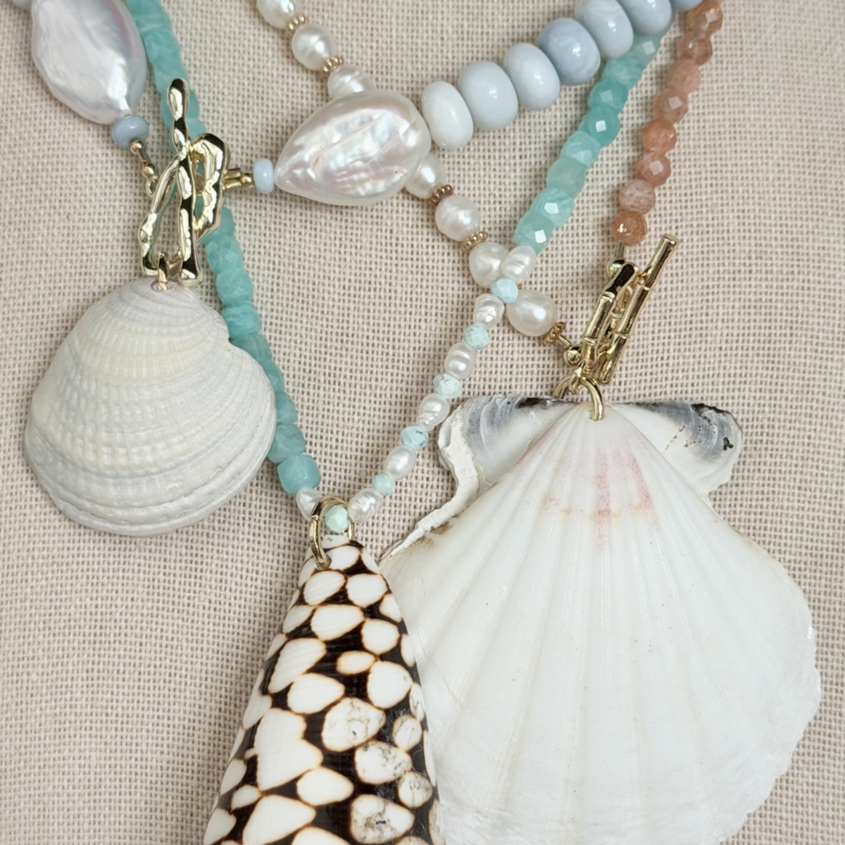 Necklace with seashells and beads on a beige fabric background