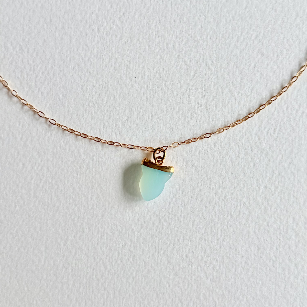 Necklace with a turquoise pendant on a light gray background