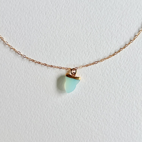 Necklace with a turquoise pendant on a light gray background