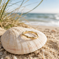 Gold ring on a seashell with a beach background