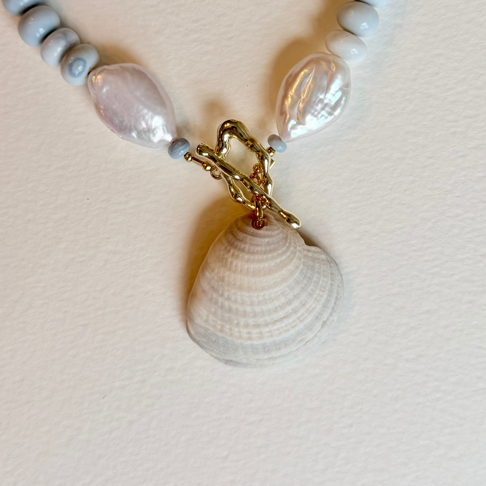 Necklace on light background showing the close up of seashell pendant