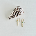 Pair of gold minnow earrings with turquoise beads on a white background
