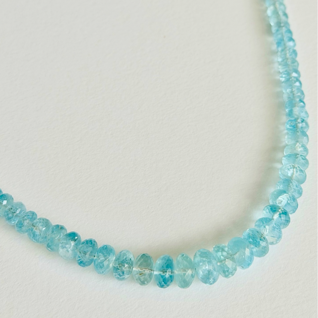 Necklace with blue beads on a light gray background