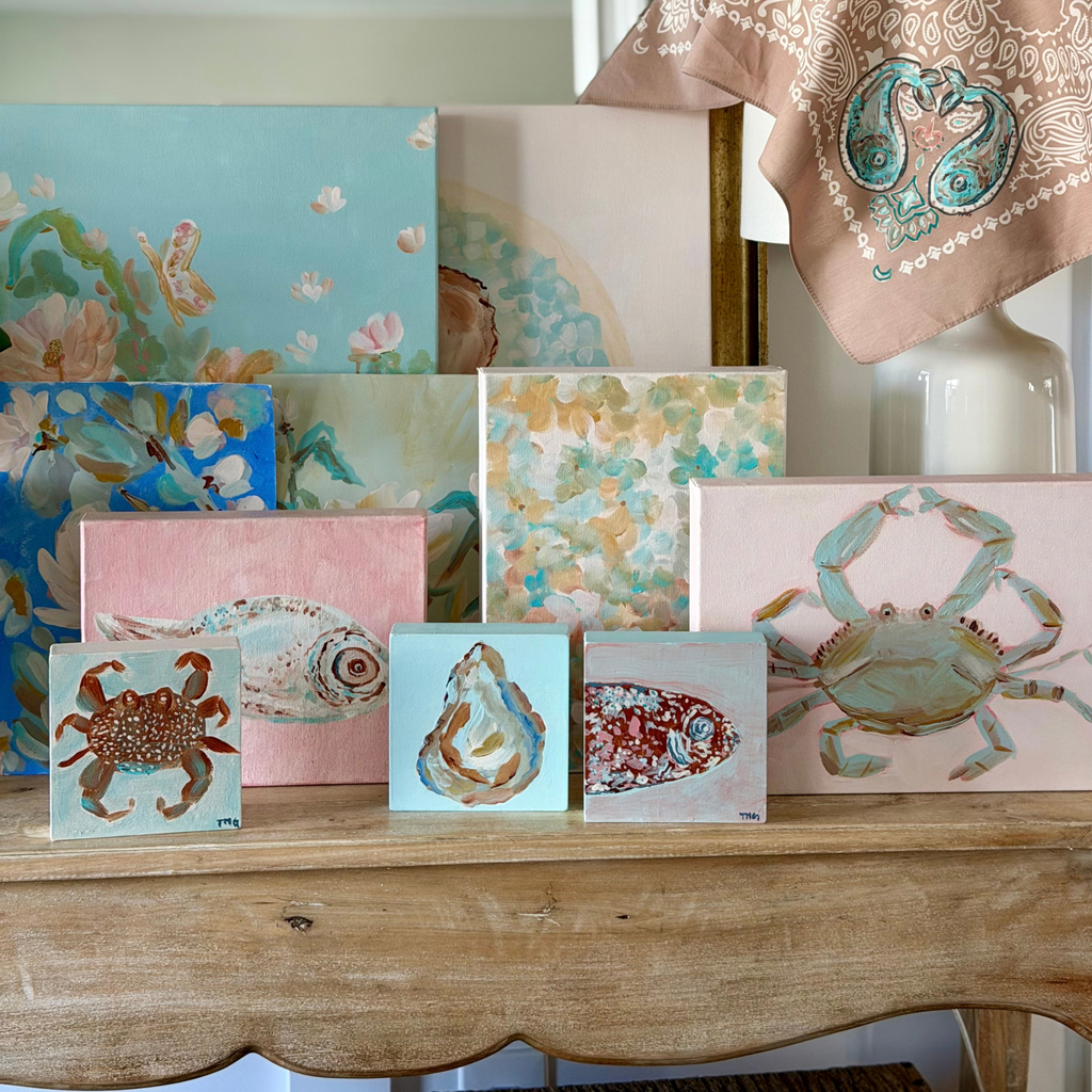 Collection of original coastal paintings by Tracy Marie Grogan, including blue crab, fish, oyster and floral artwork displayed with a hand-painted bandana.