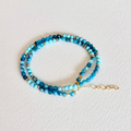 Turquoise beaded bracelet on a light gray background
