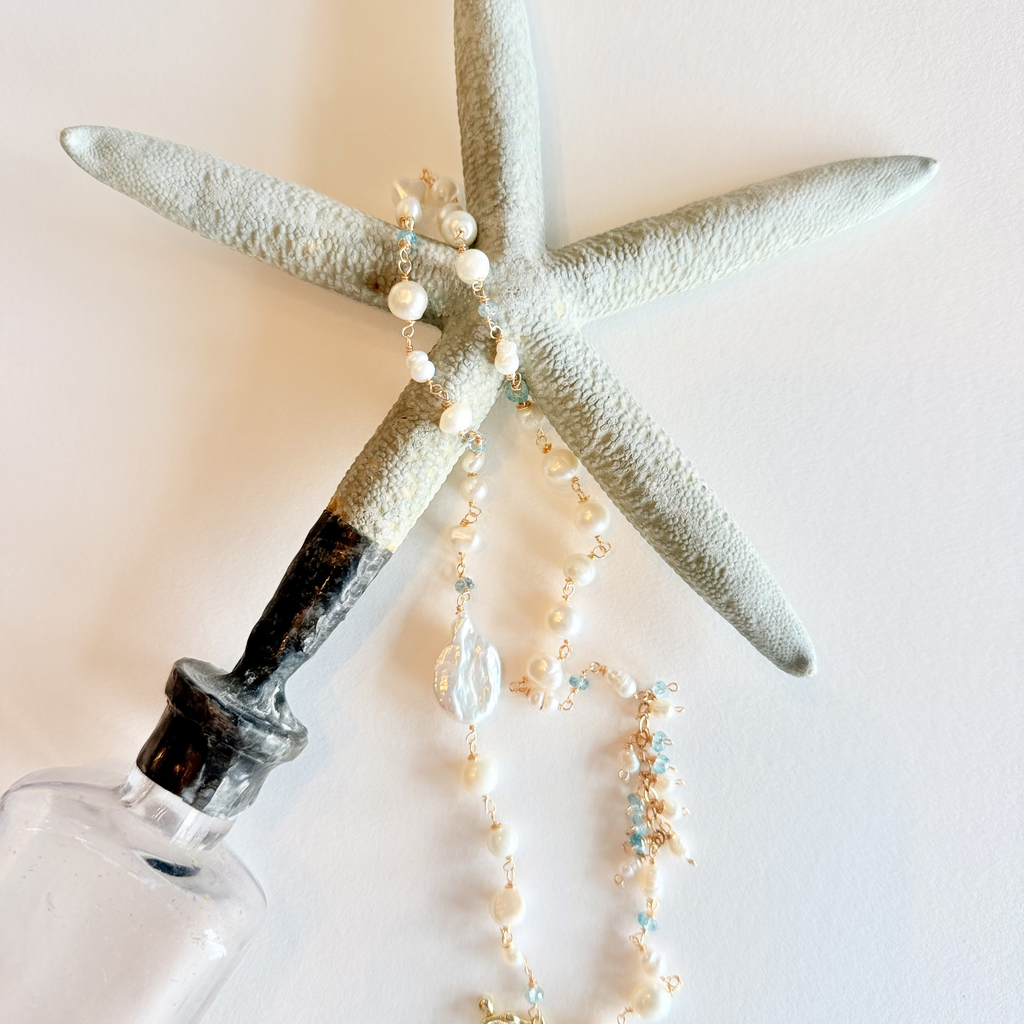 Starfish with a necklace draped over it on a light background