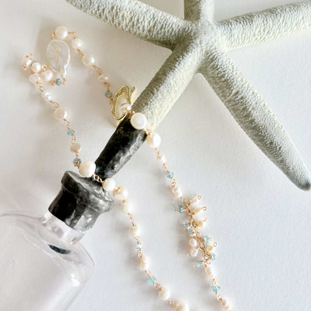 Pearl necklace with starfish on a white background