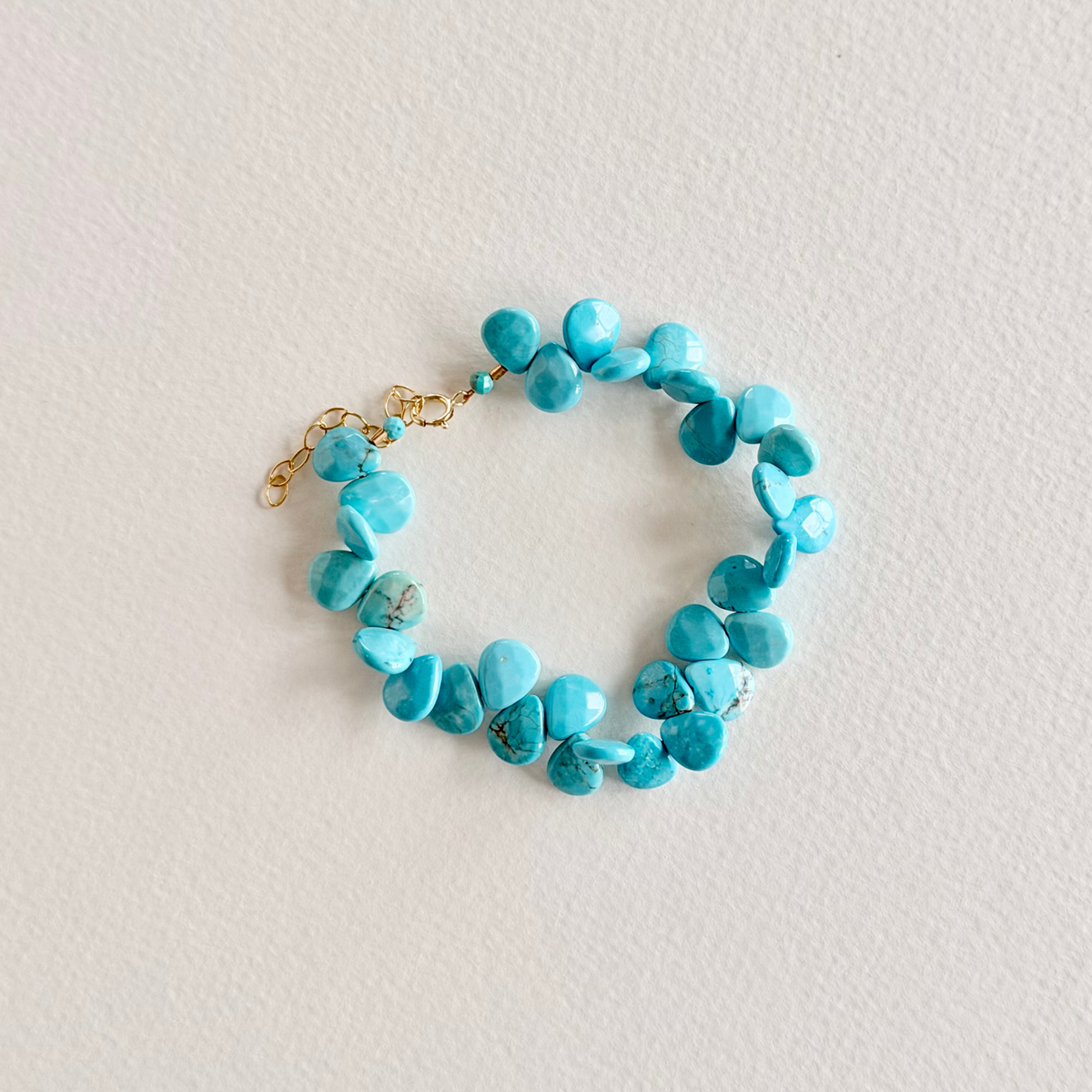 Turquoise beaded bracelet on a light gray background
