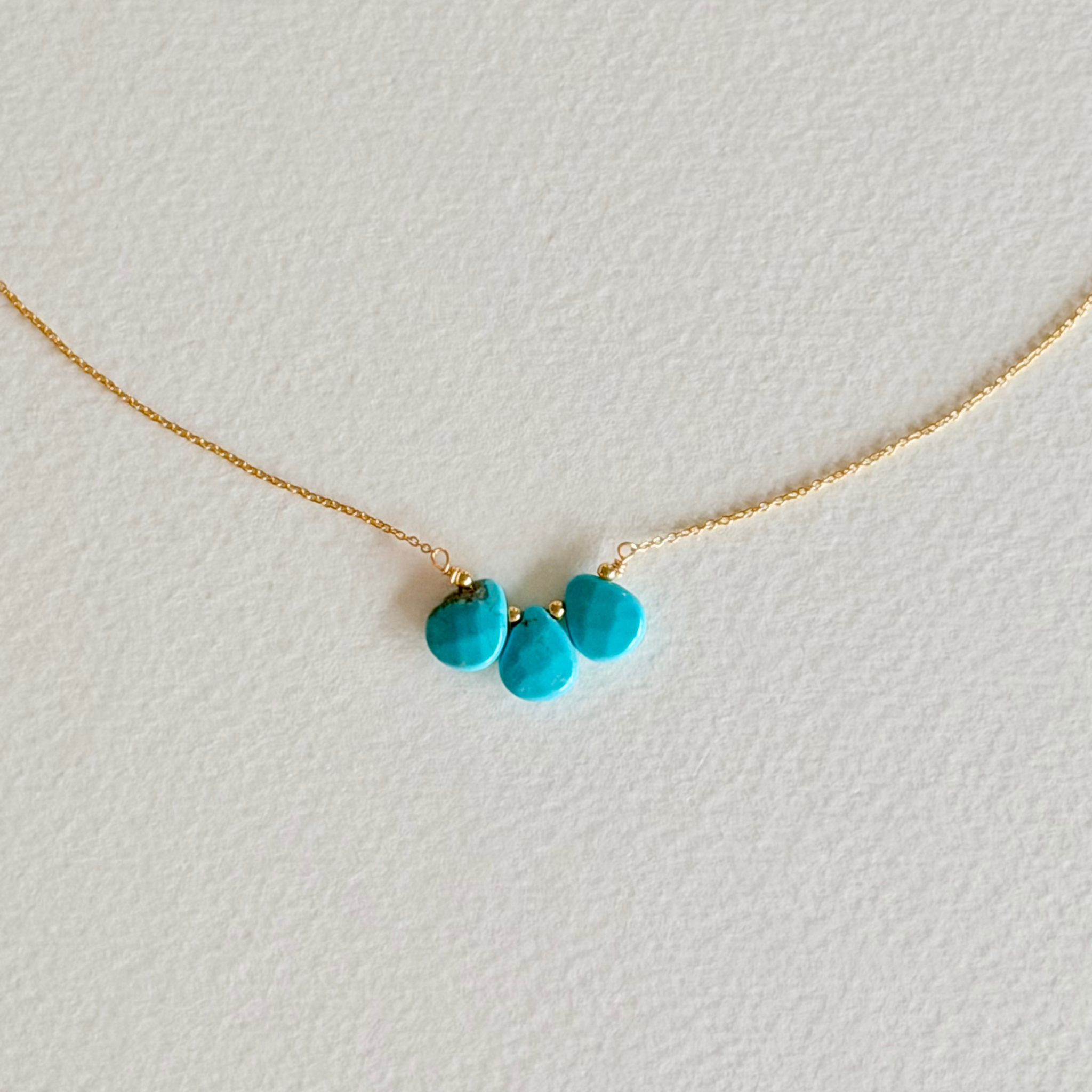 Necklace with turquoise beads on a light gray background