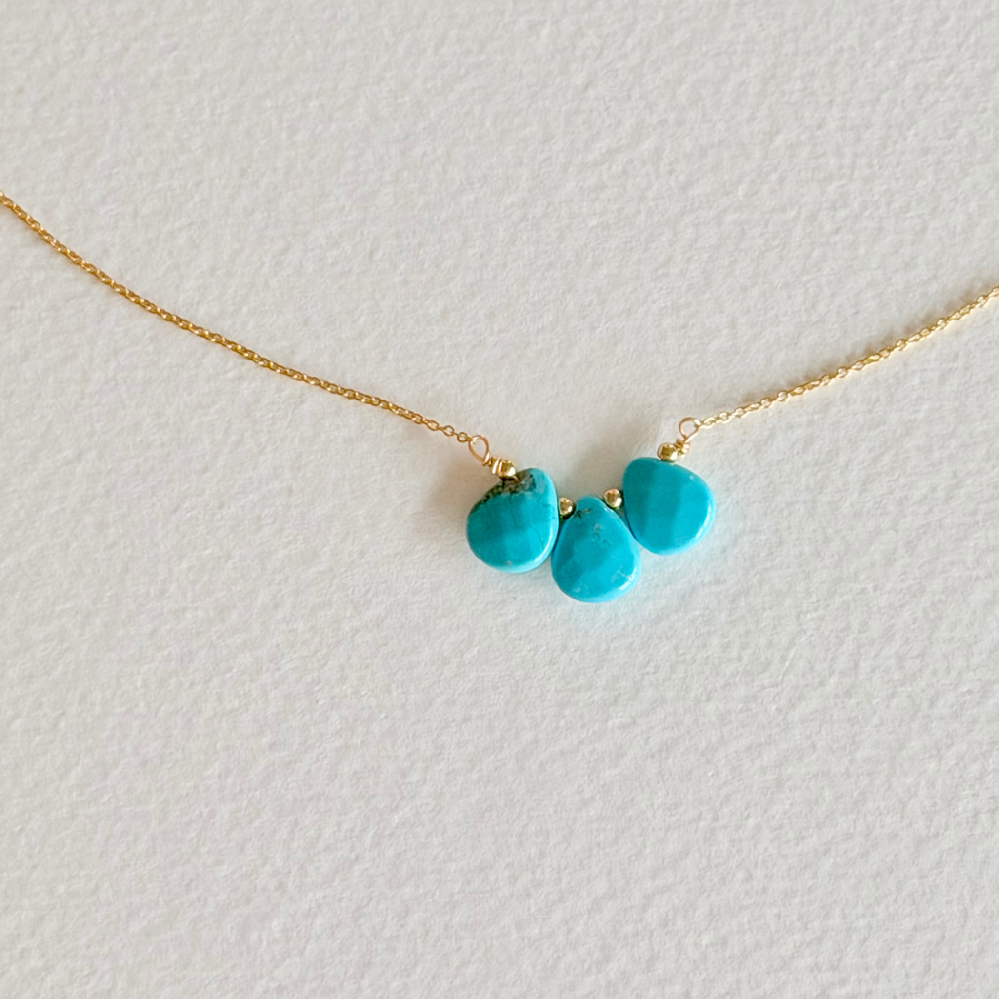 Necklace with turquoise pendants on a light background