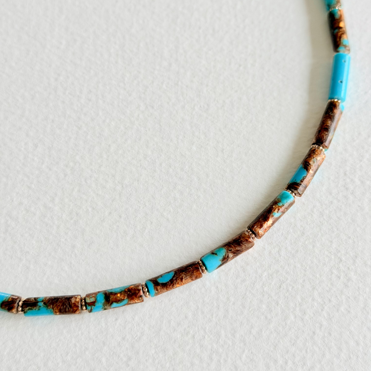 Necklace with turquoise and brown beads on a white background