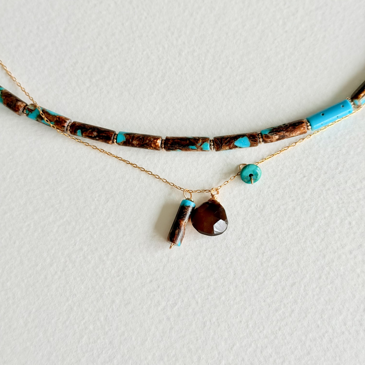 Necklace with turquoise and brown beads on a white background