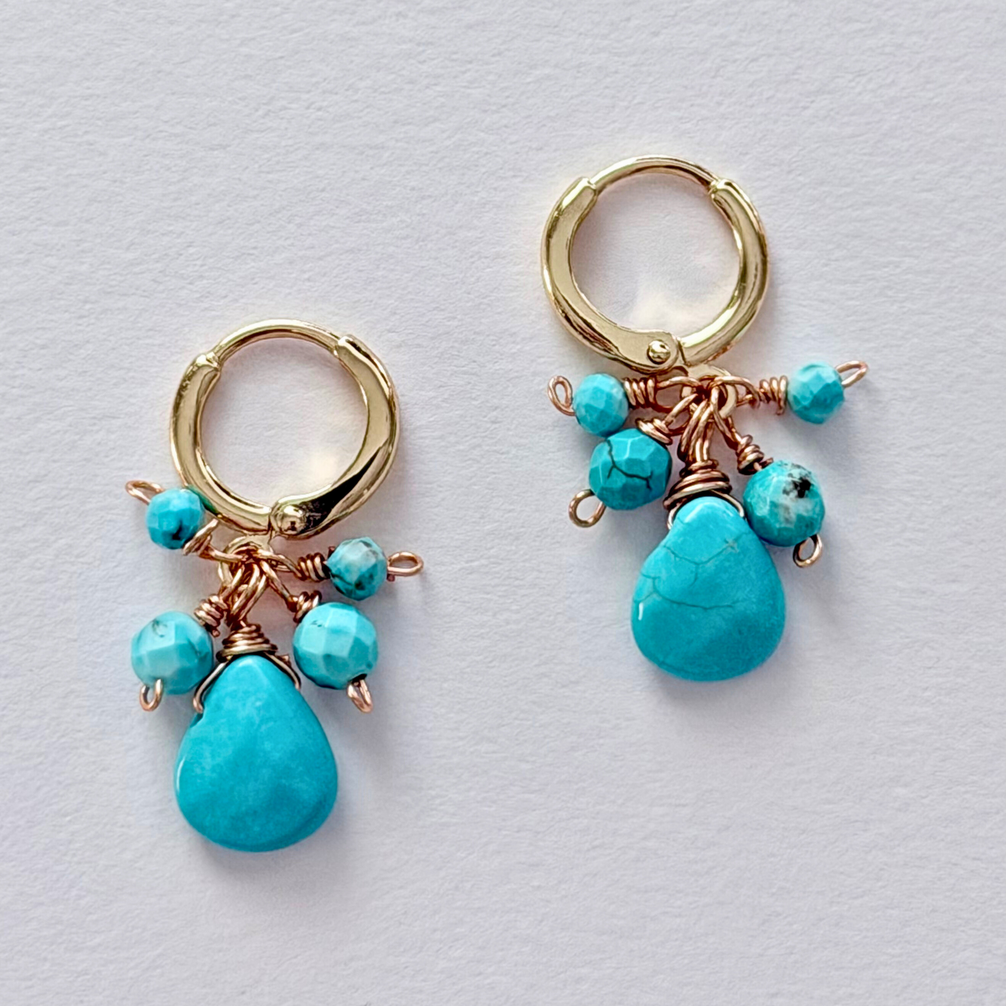 14k Gold filled hoop earrings with turquoise beads on a light gray background