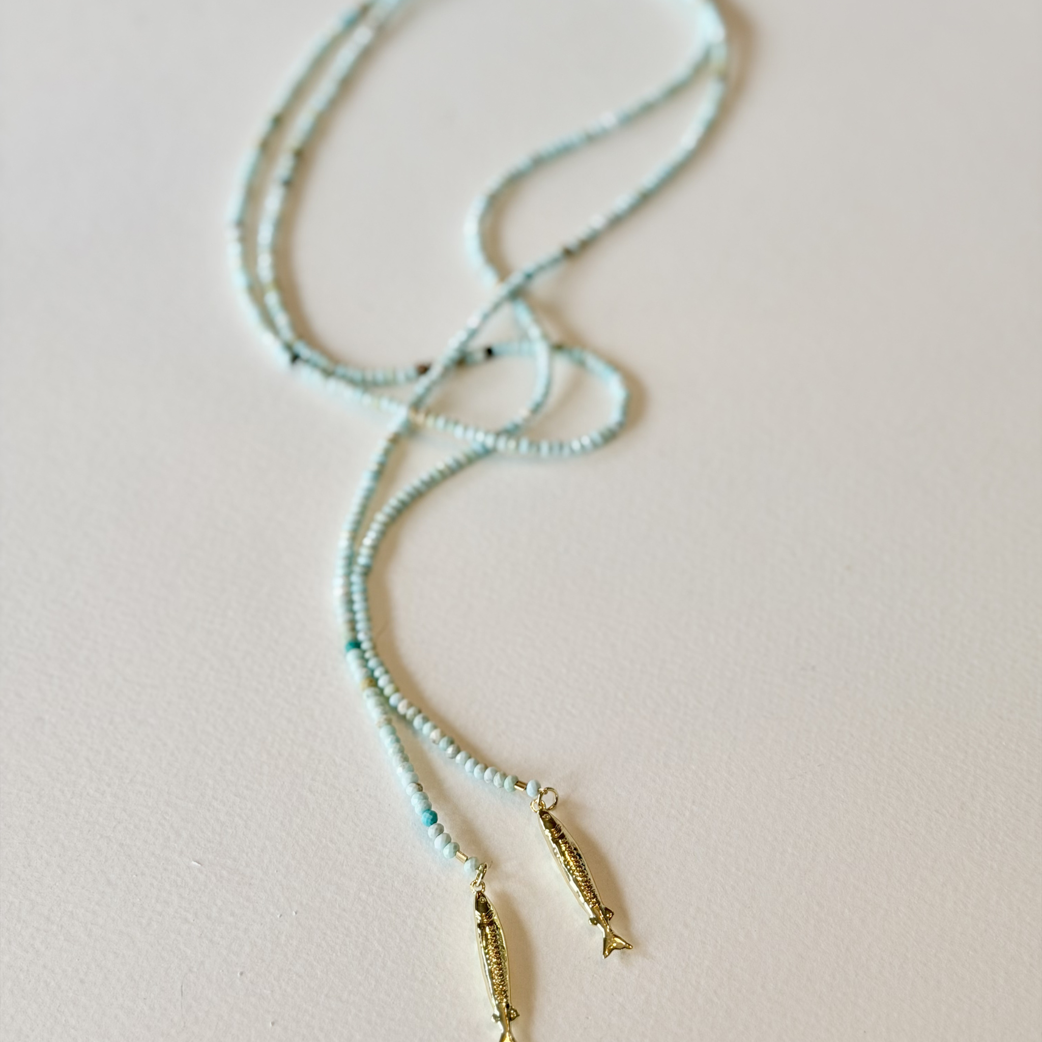 Beaded necklace with gold accents on a beige background